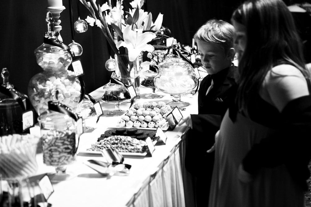 A boy and a girl are looking at a buffet table.