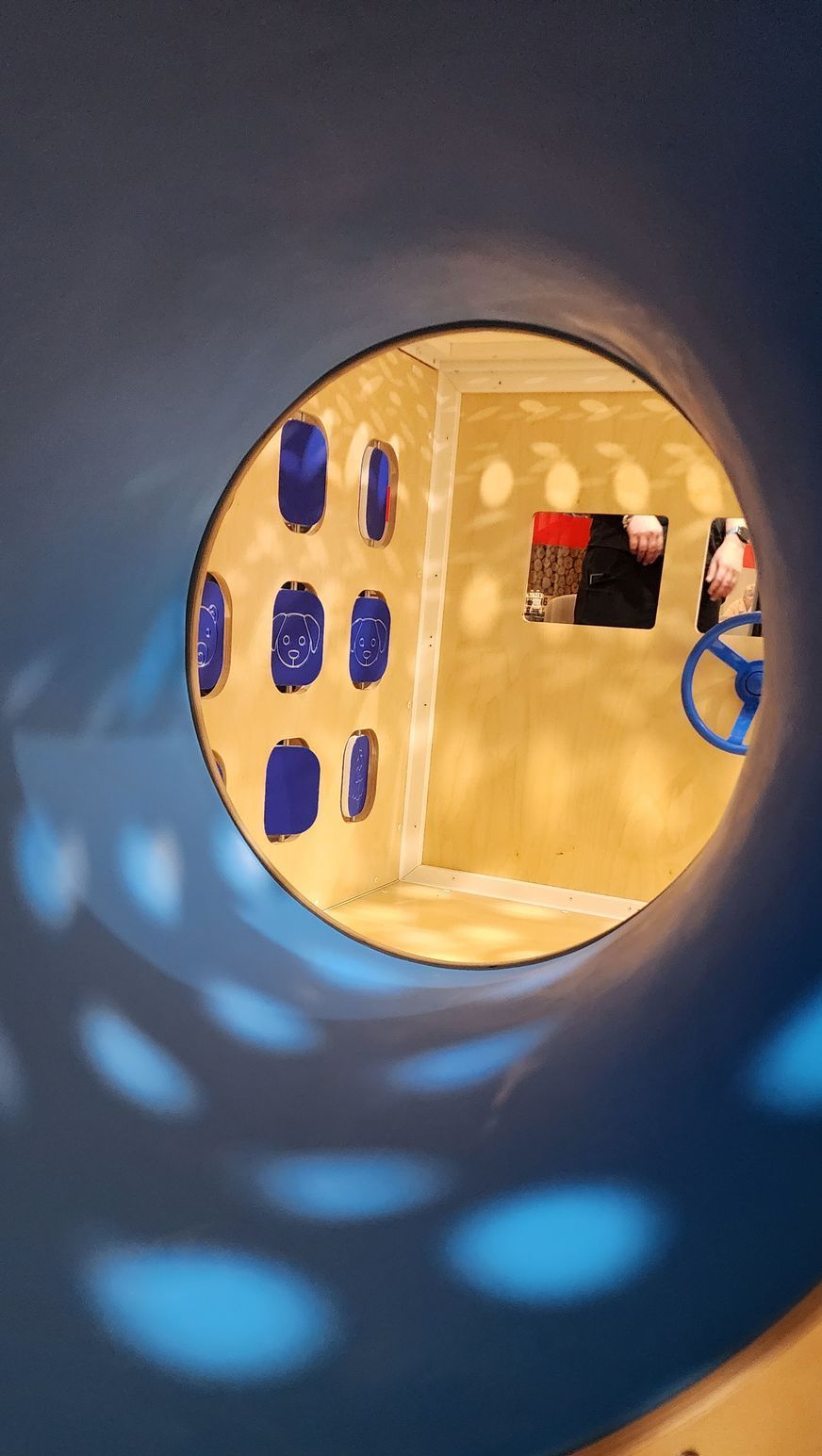 A view into children's playroom through a blue tunnel