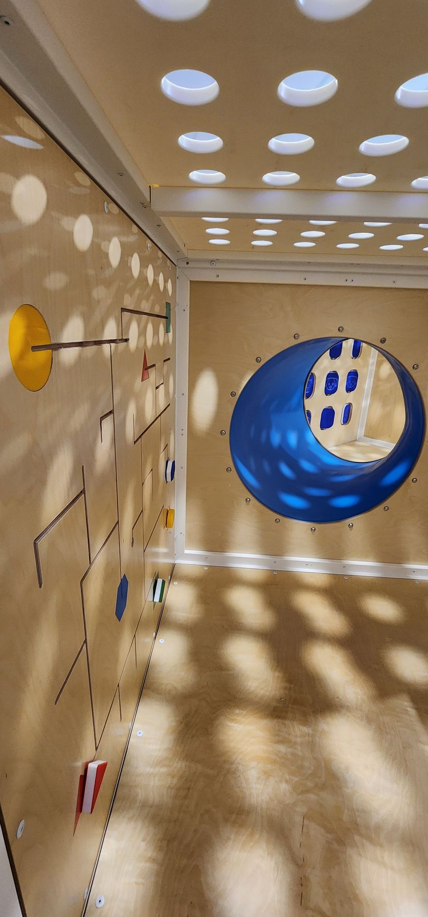 A children's playroom with a blue tunnel