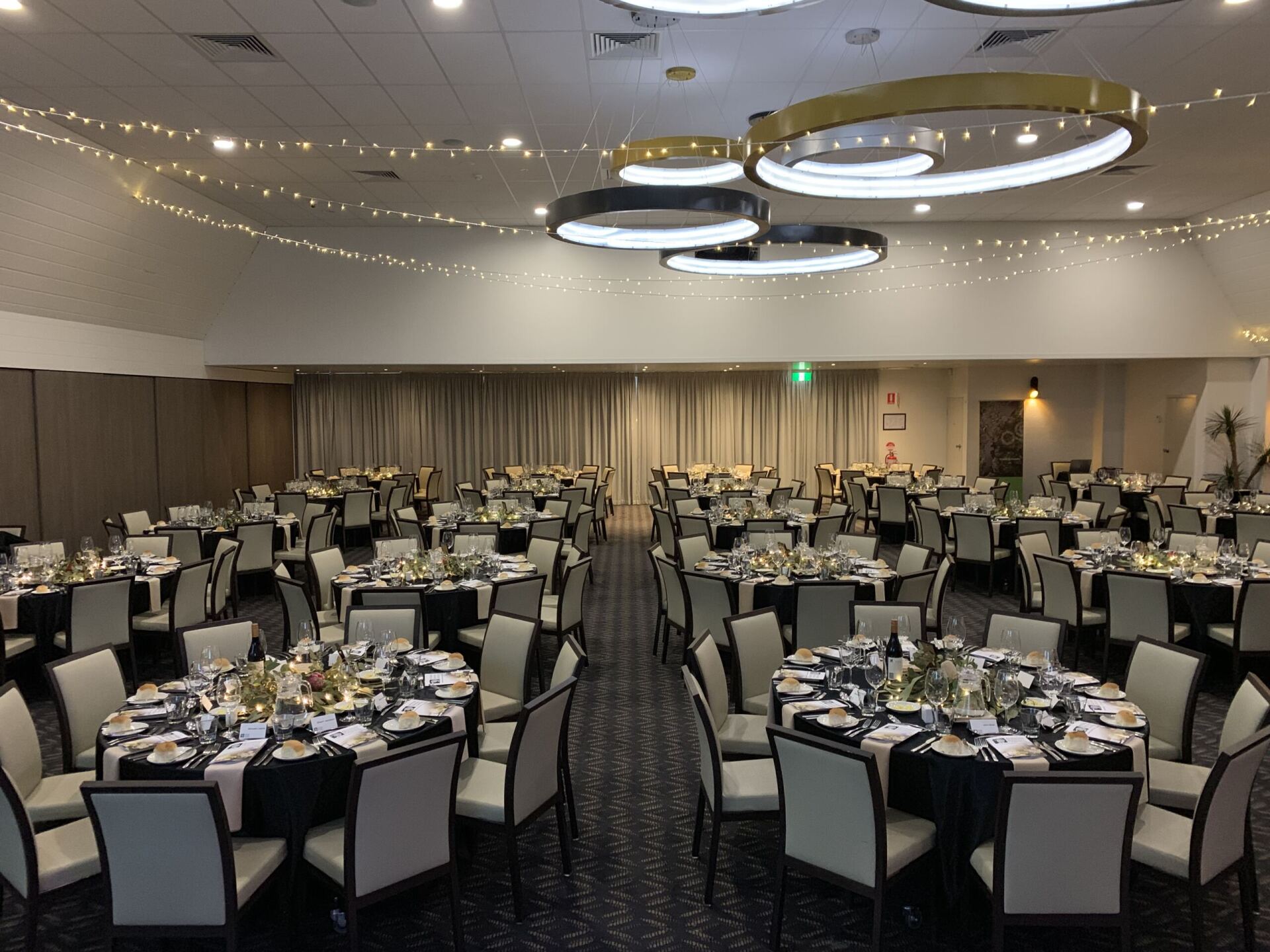 A large room with tables and chairs set up for a banquet