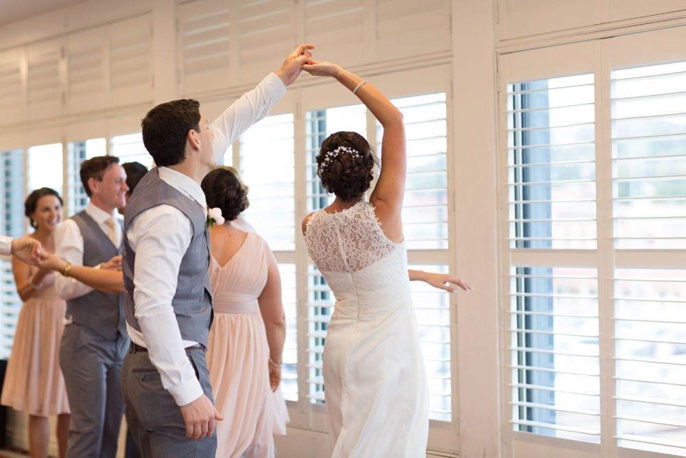 A bride and groom are dancing with their wedding party