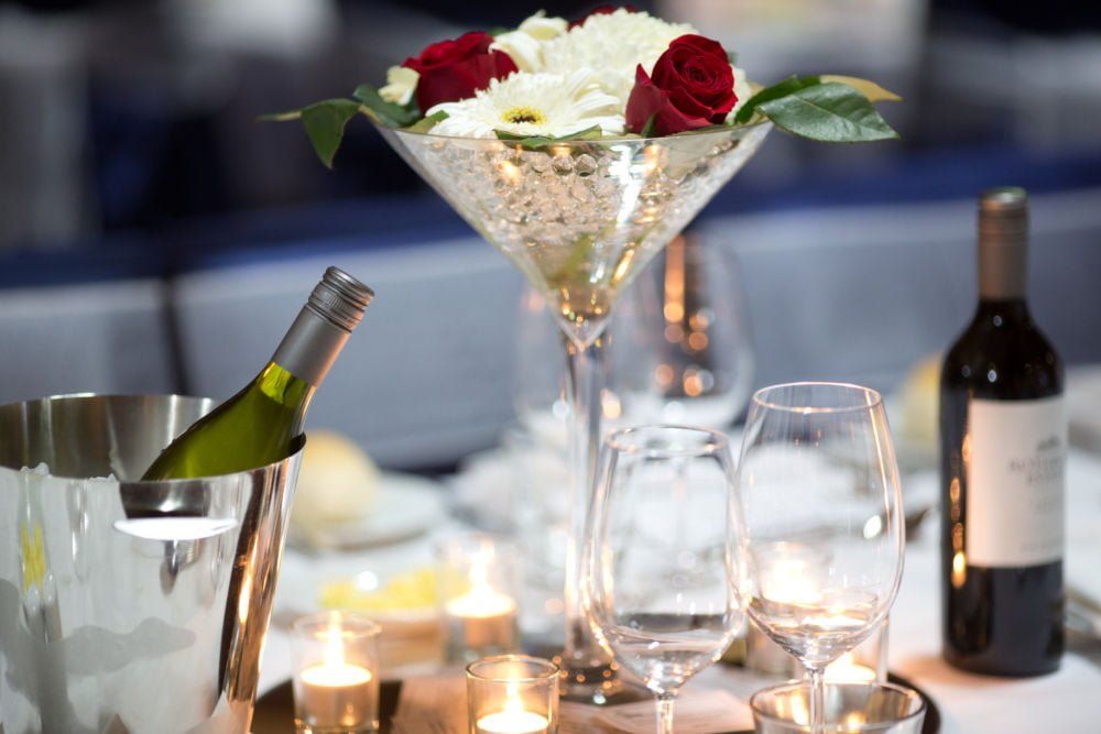 A martini glass filled with flowers sits on a table