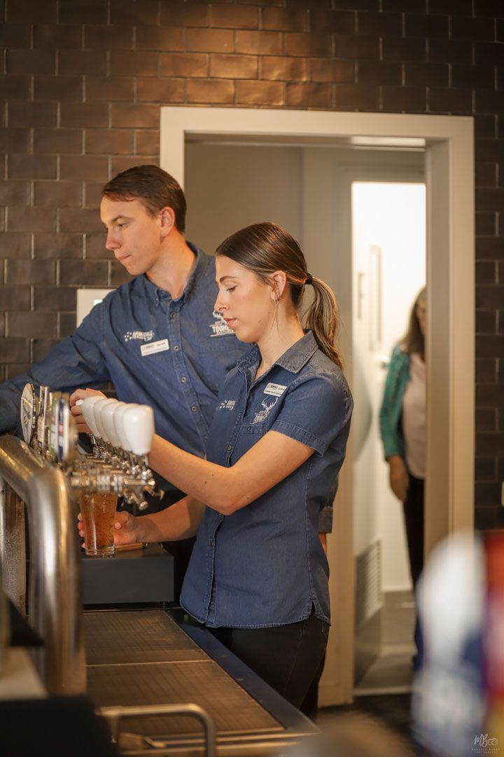 A man and a woman are working at a bar