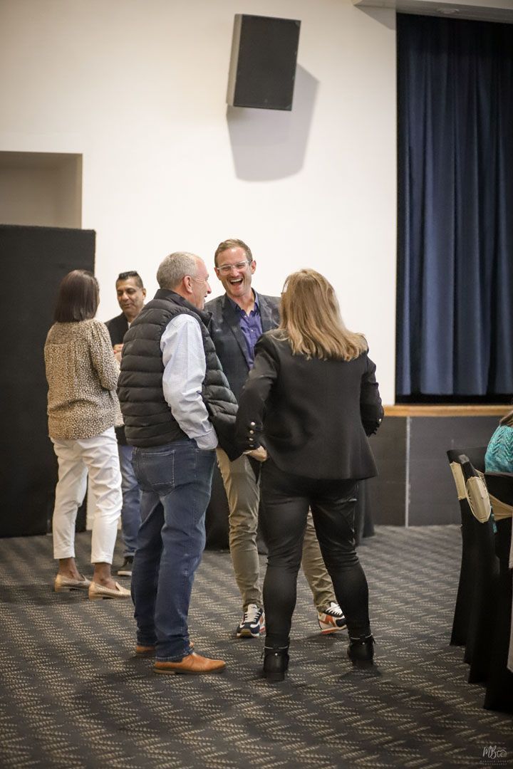 A group of people are standing in a room talking to each other