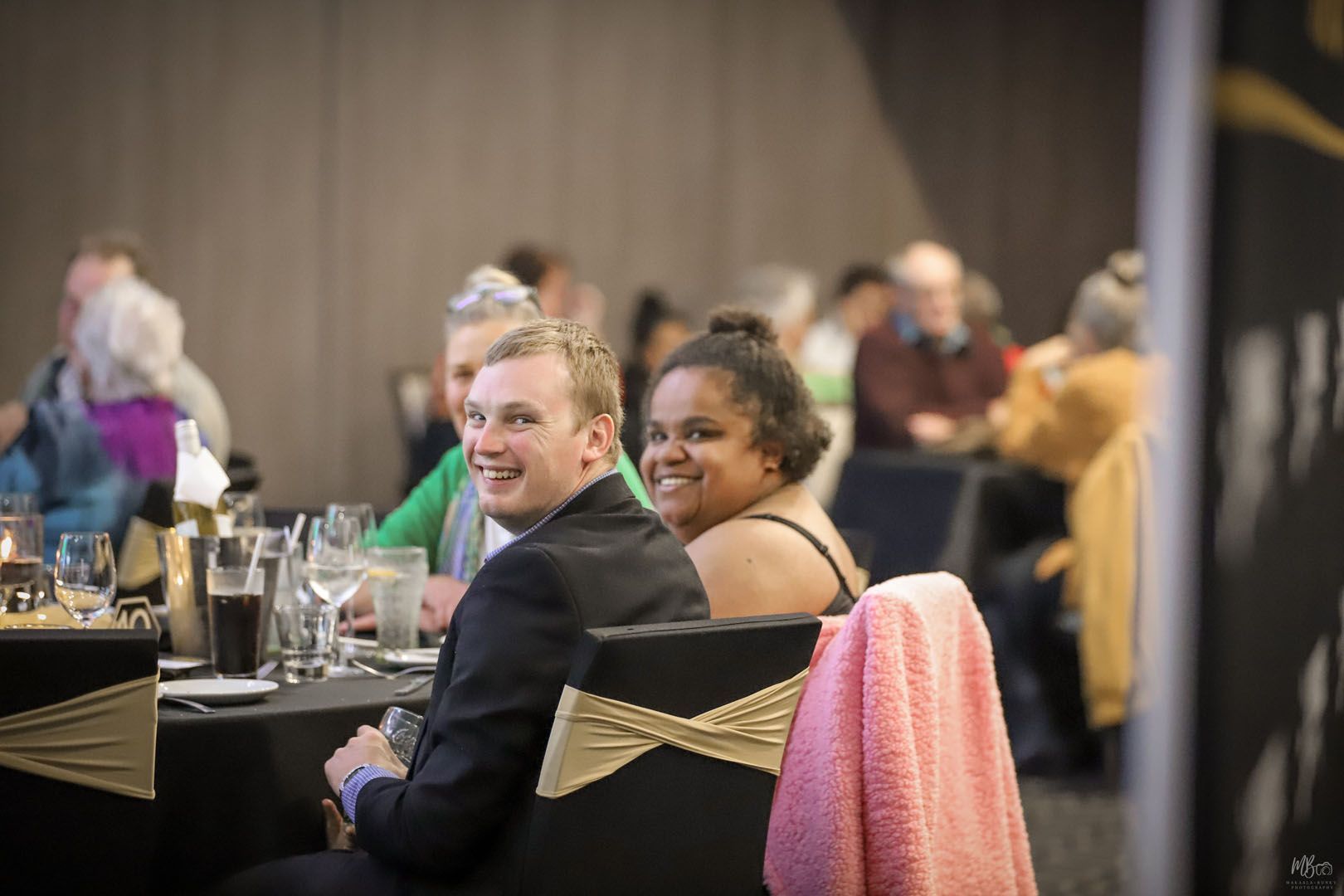 A man and a woman are sitting at a table at a party