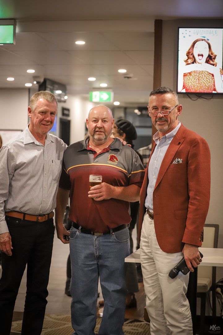 Three men are posing for a picture in a room