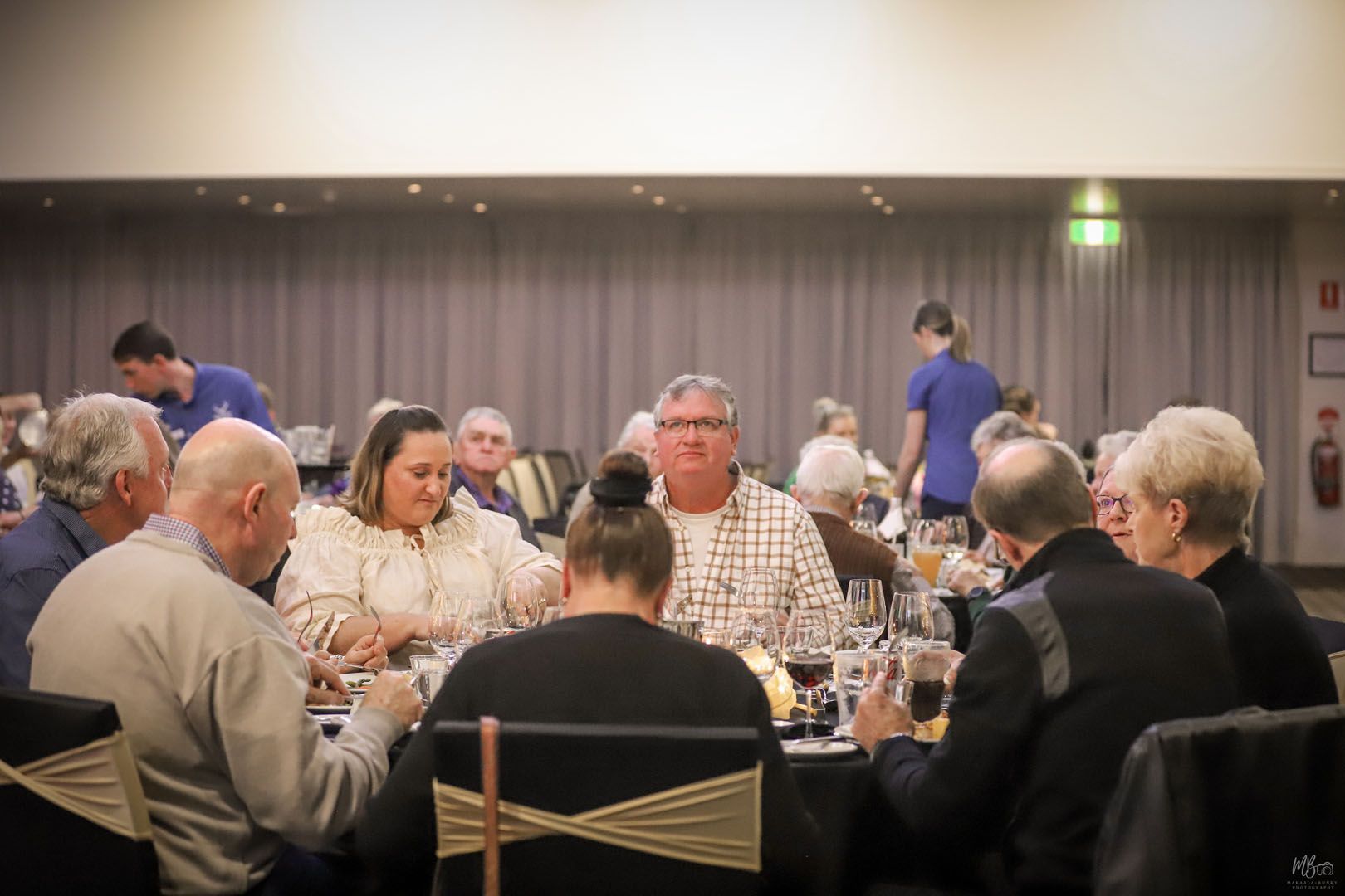 A group of people are sitting at a table with glasses of wine