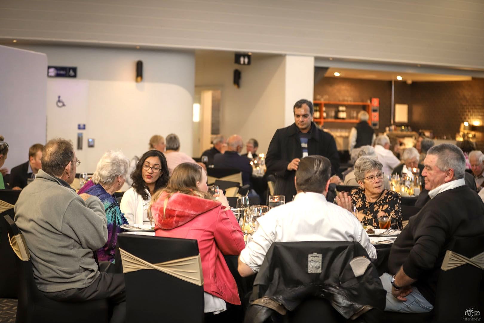 A group of people are sitting at tables in a restaurant