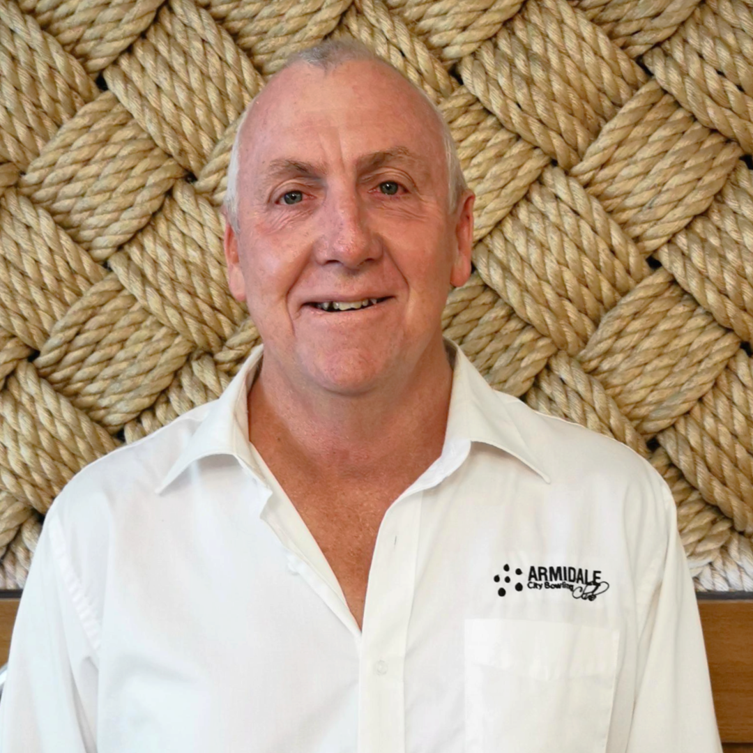 A man (Andrew Carey) wearing a white shirt that says Armidale City Bowling Club on it