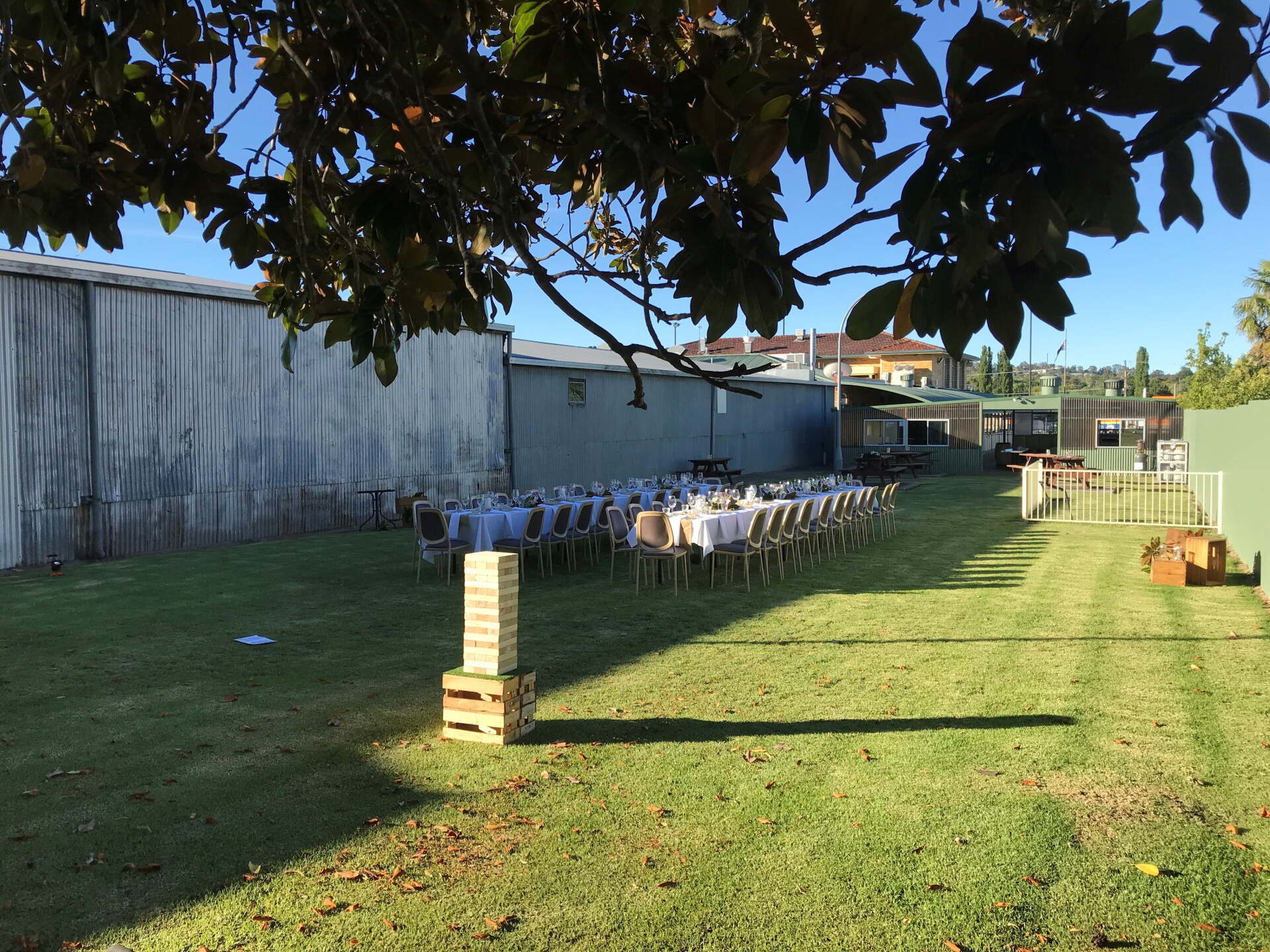 A row of tables and chairs in a grassy yard