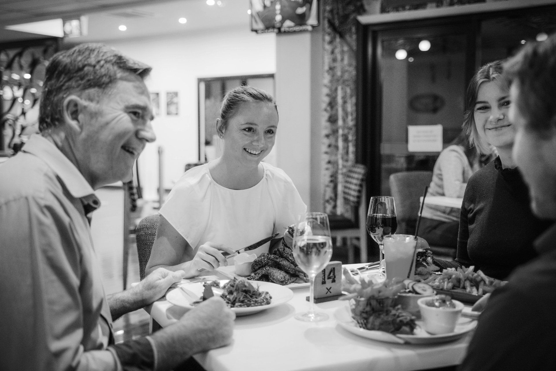 A group of people are sitting at a table in a restaurant eating food.