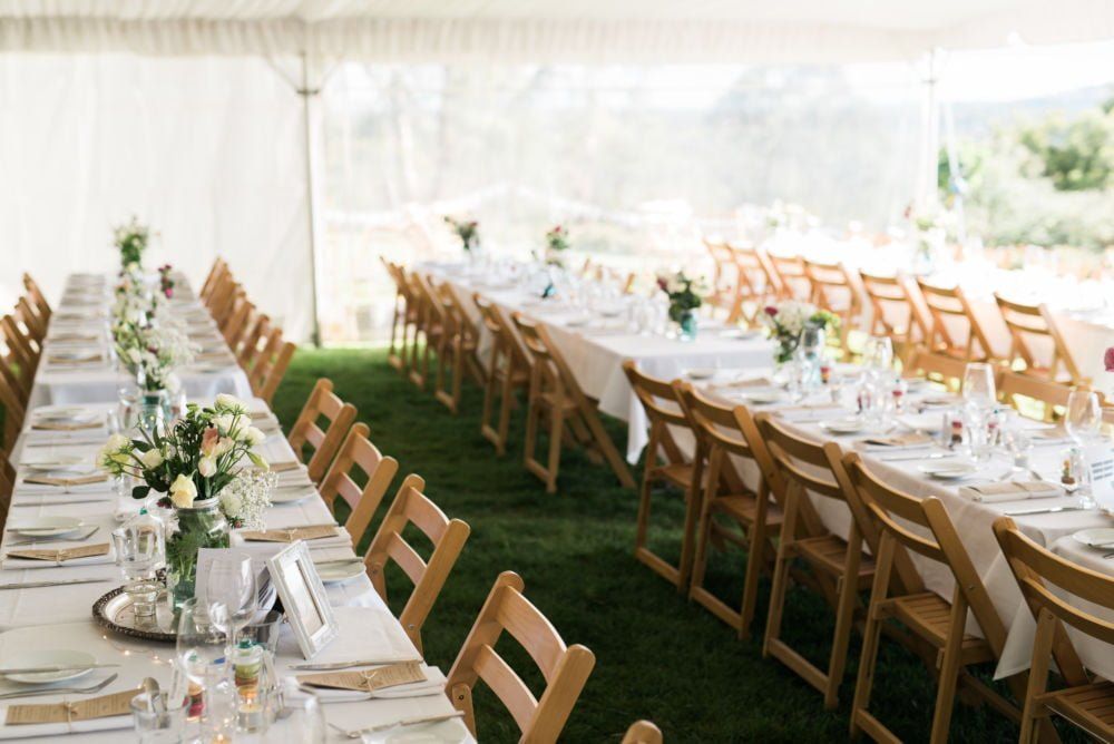 A long table set up for a wedding reception in a tent