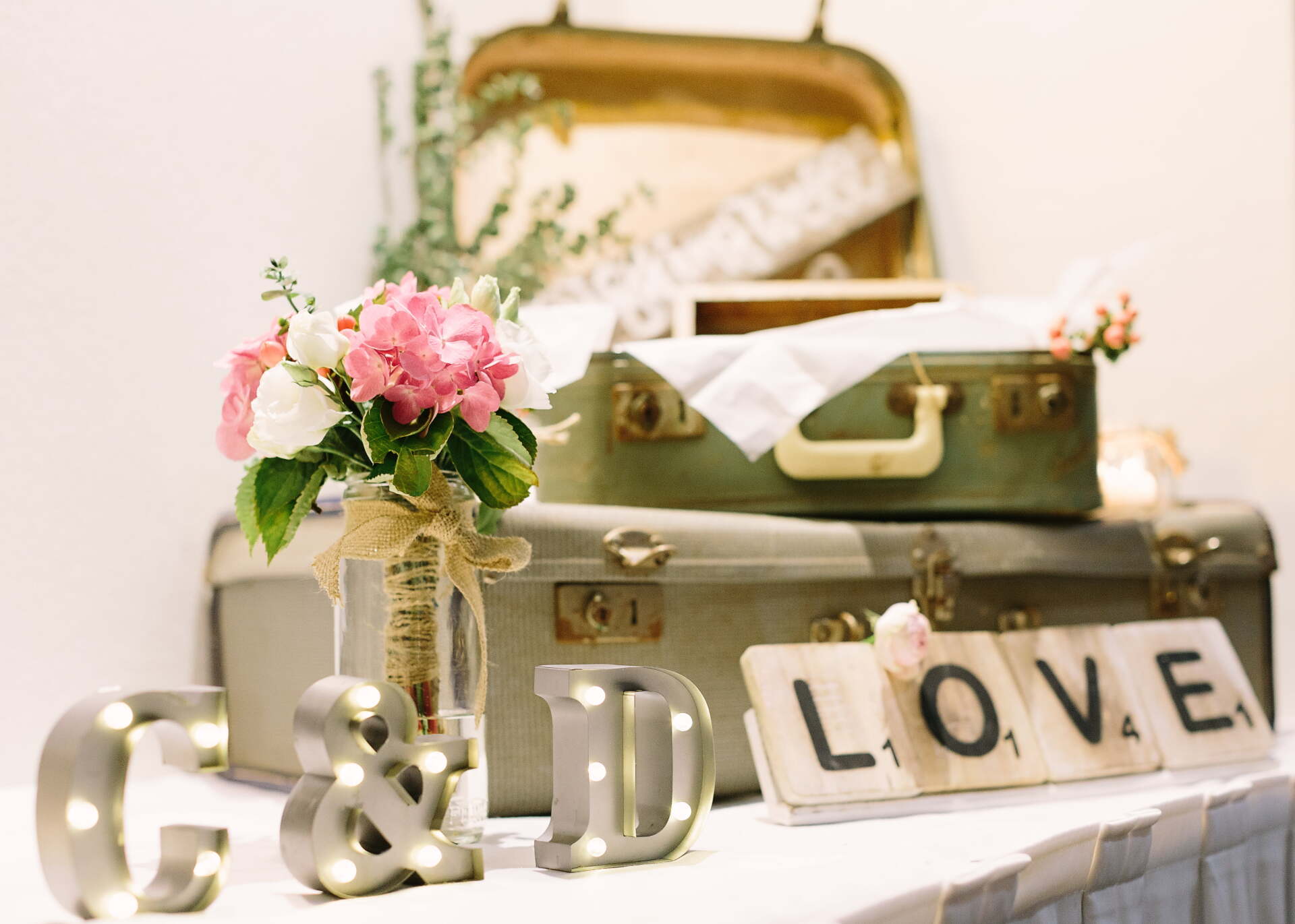 A table with a suitcase and a sign that says LOVE