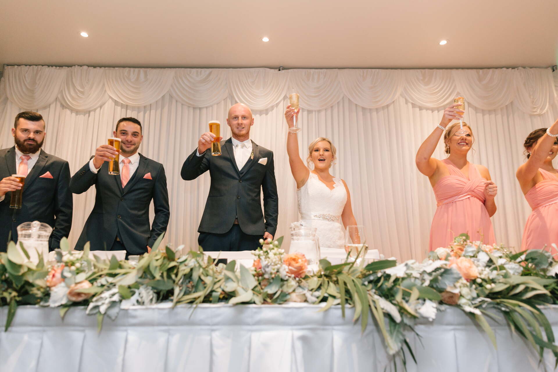 The bride and groom are toasting with their wedding party