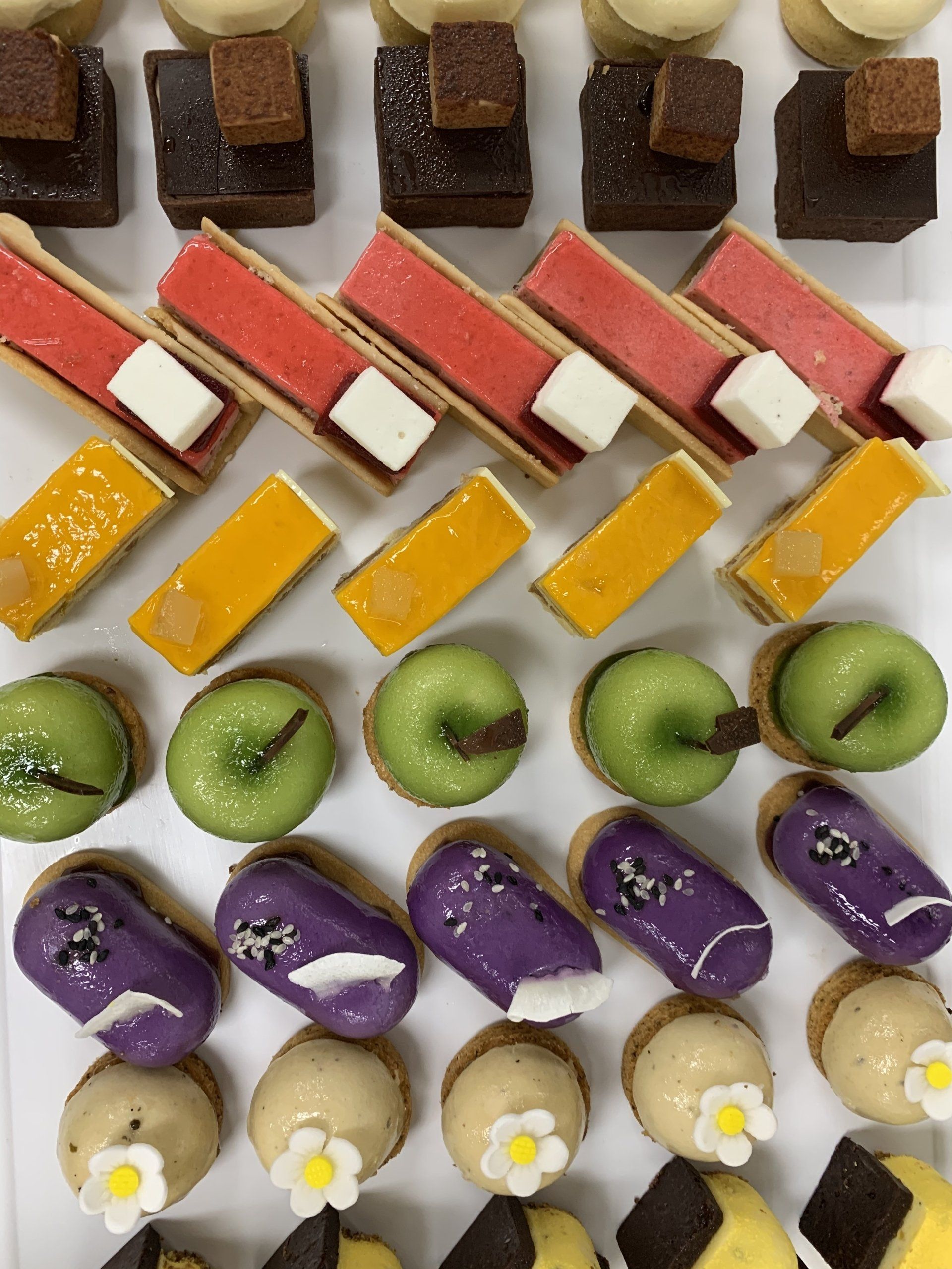 A variety of desserts are lined up on a table