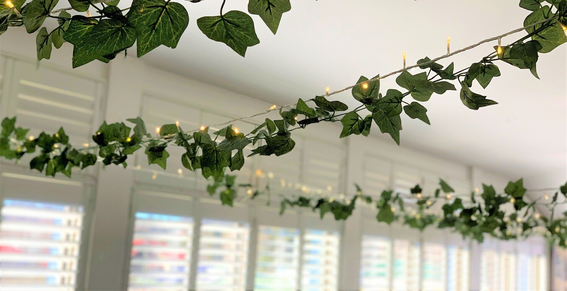 A string of green leaves and lights hanging from the ceiling