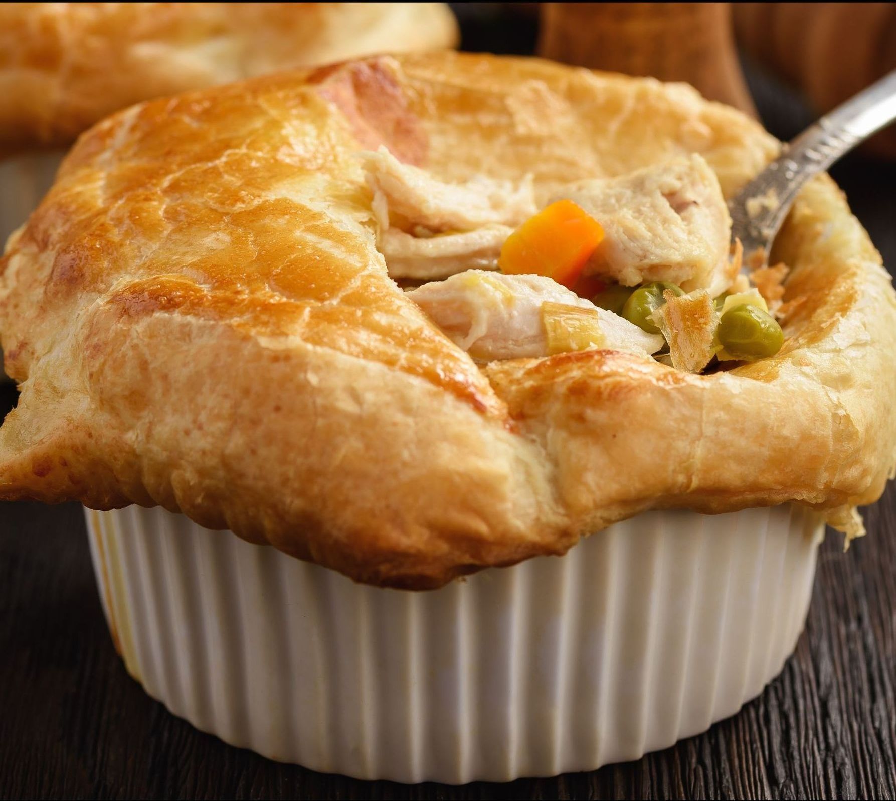 A bowl of chicken pot pie with a fork in it