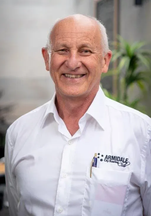A man in a white shirt is smiling