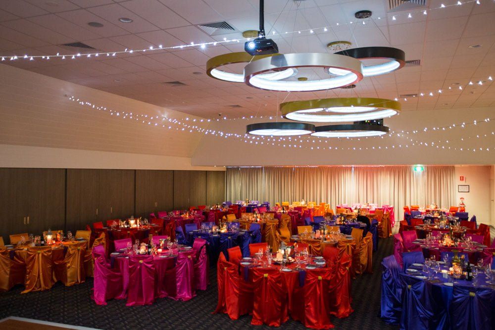 A large room with tables and chairs set up for a party