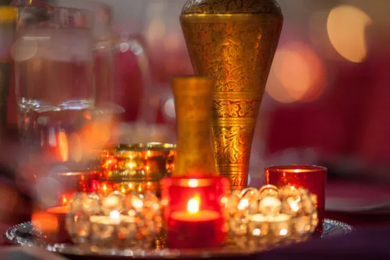 A table with candles and a vase on it