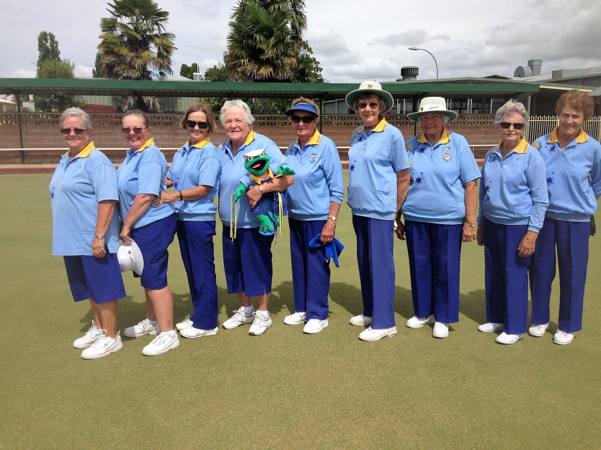 A group of women standing in a line wearing blue shirts and pants