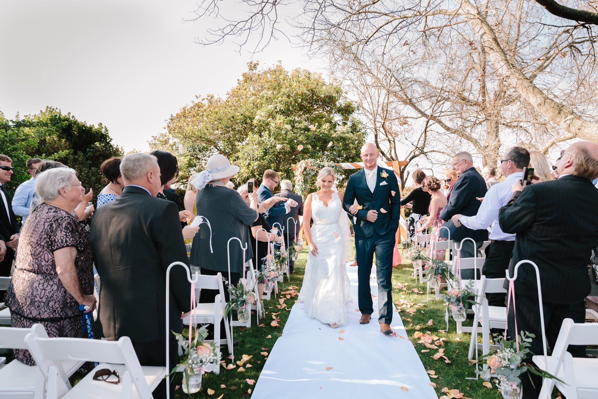 A bride and groom are walking down the aisle at their wedding
