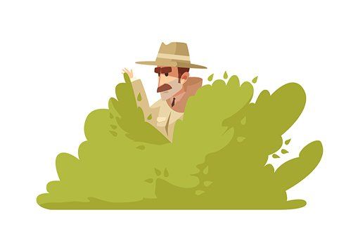 a man in a hat is peeking out of a bush .