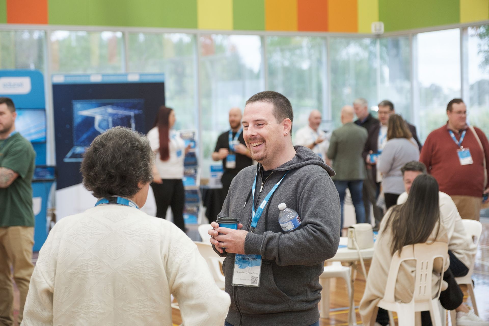 a group of people are standing around a long table filled with hamburgers .