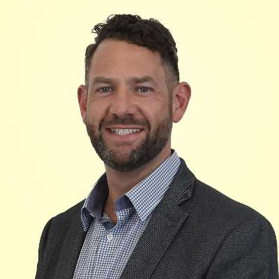 a man with a beard is wearing a suit and smiling .