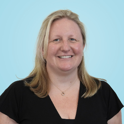 a woman wearing a black shirt and a necklace is smiling for the camera .