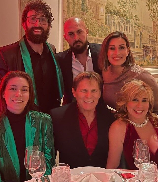 Mike and Barbara Ross posing for a picture at a table with wine glasses