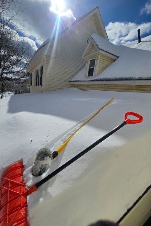 A snow shovel is sitting in front of a house