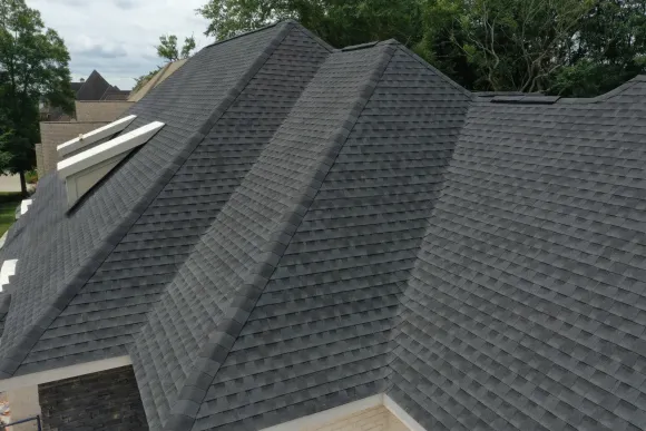 The roof of a house has a lot of shingles on it.