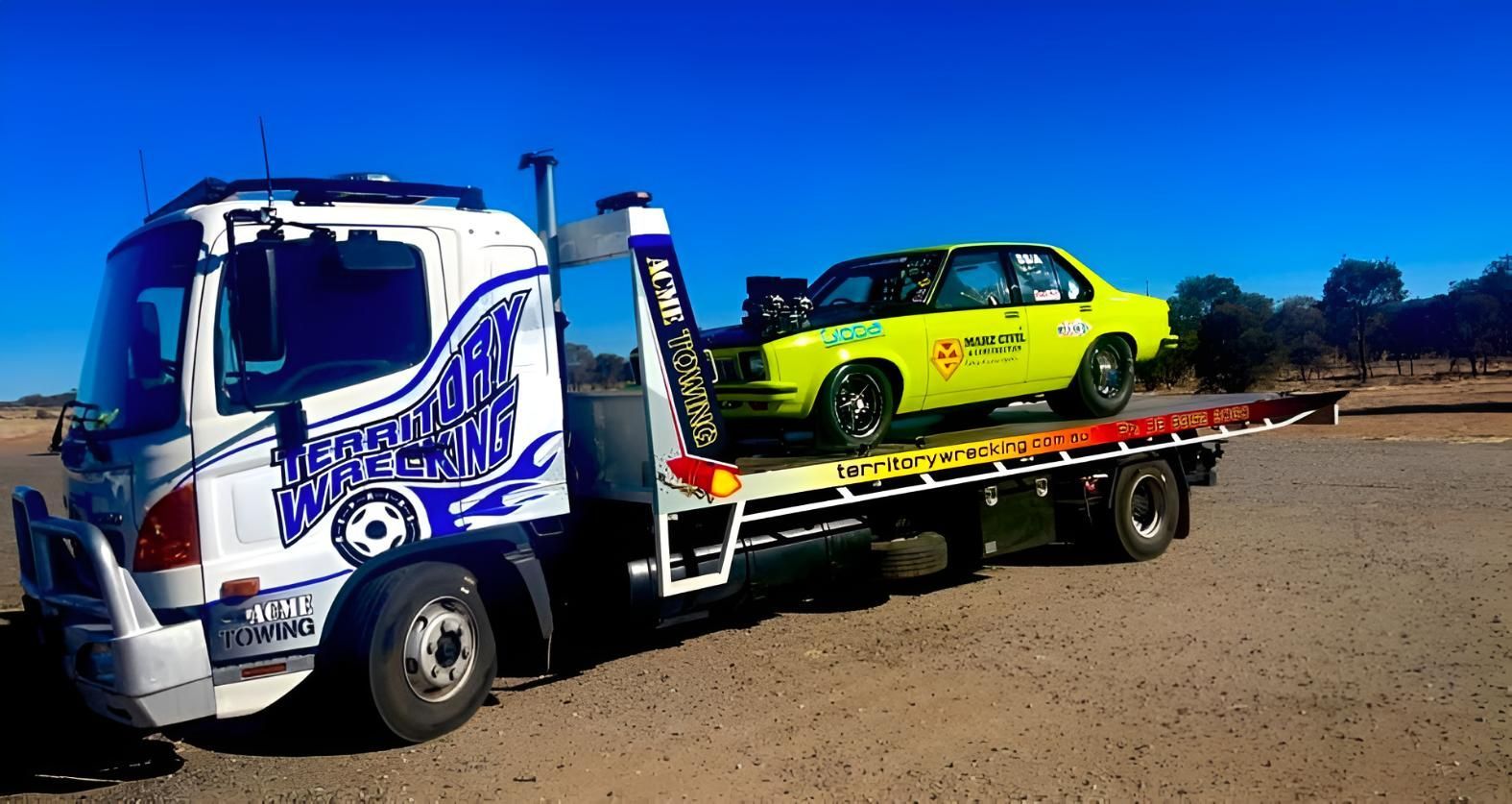 A Yellow Car Is Being Towed By A Tow Truck — Territory Wrecking Repairs In Alice Springs, NT