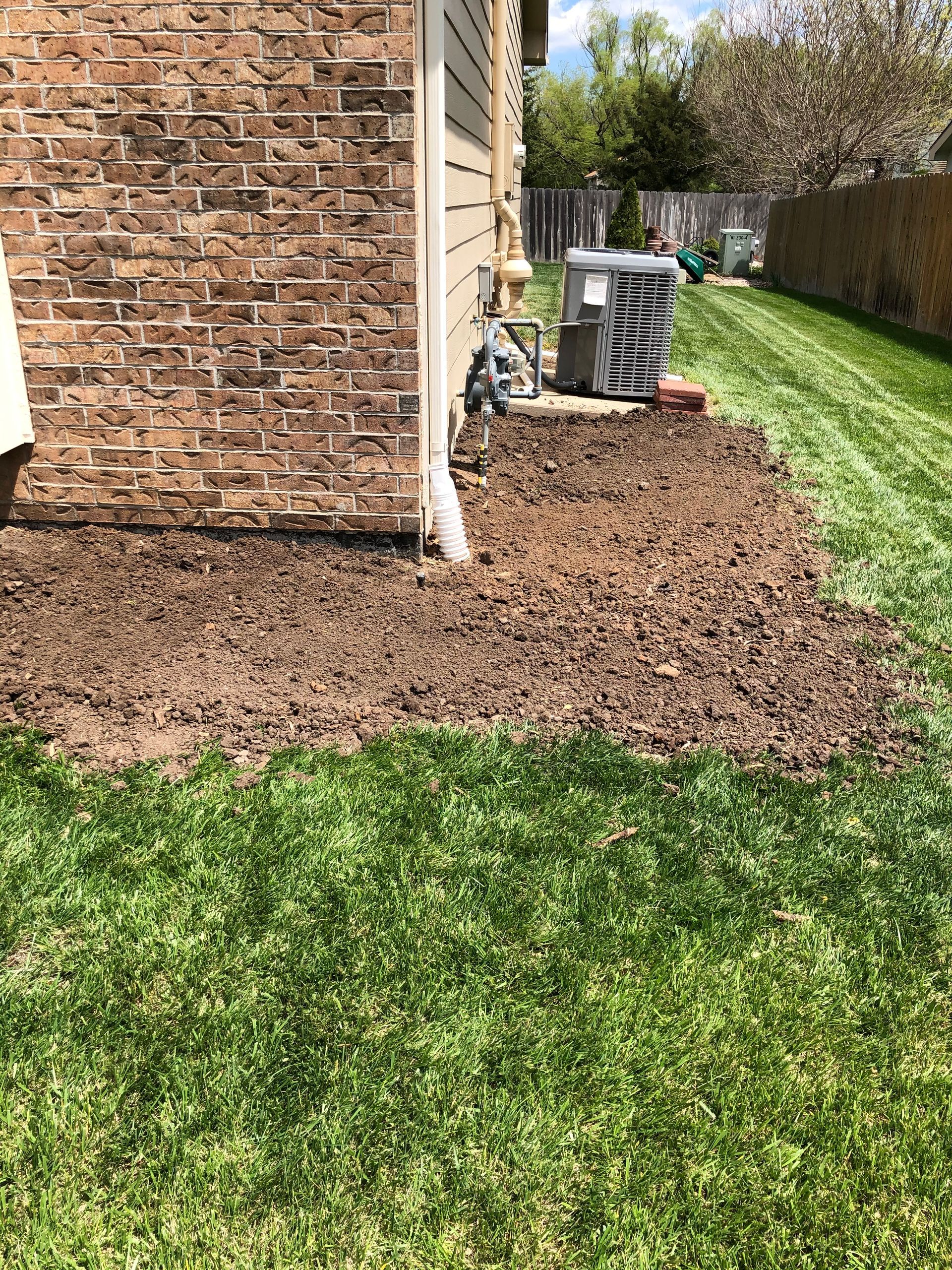 a brick house with a lush green lawn in front of it .