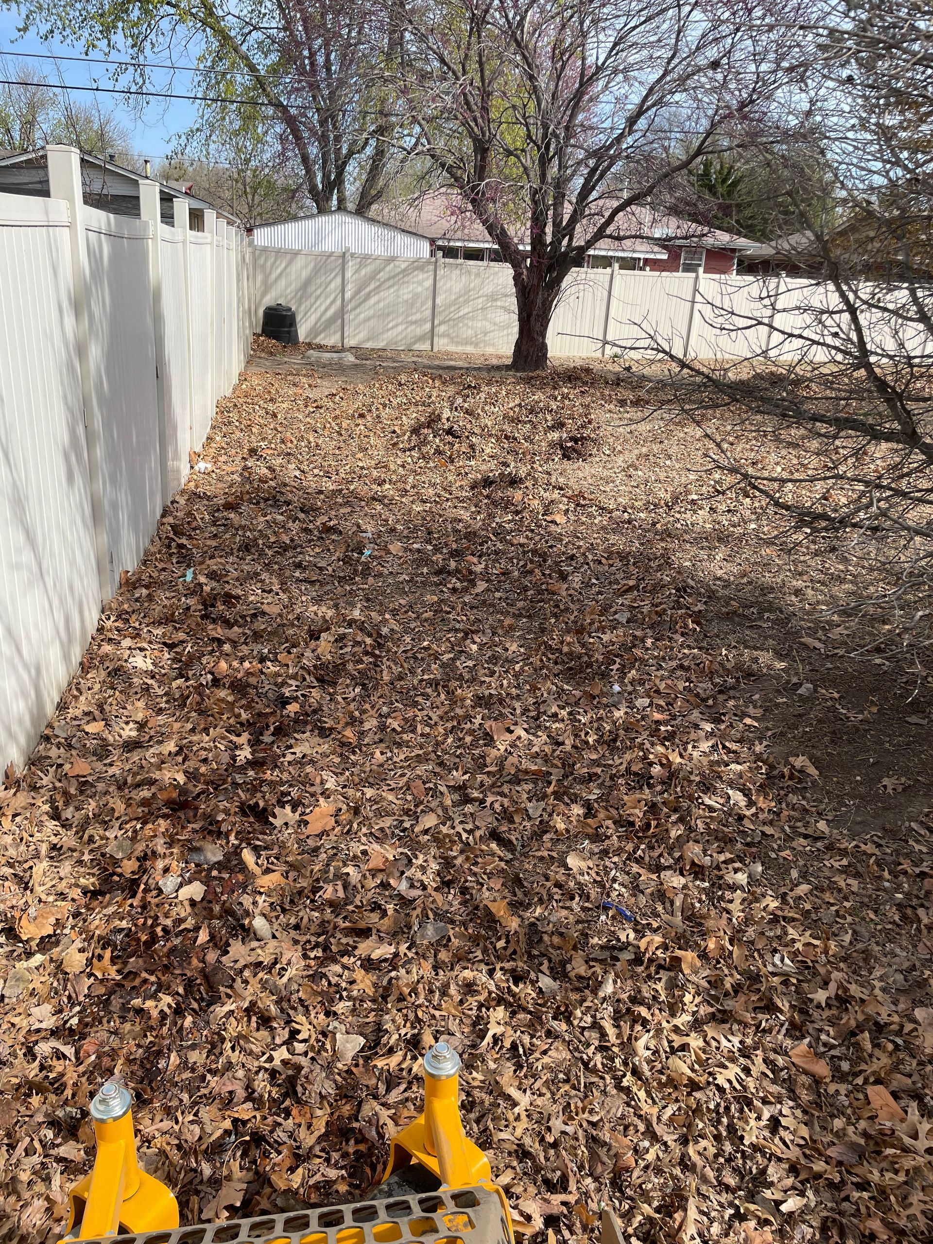 a bunch of leaves are laying on the ground in a yard .