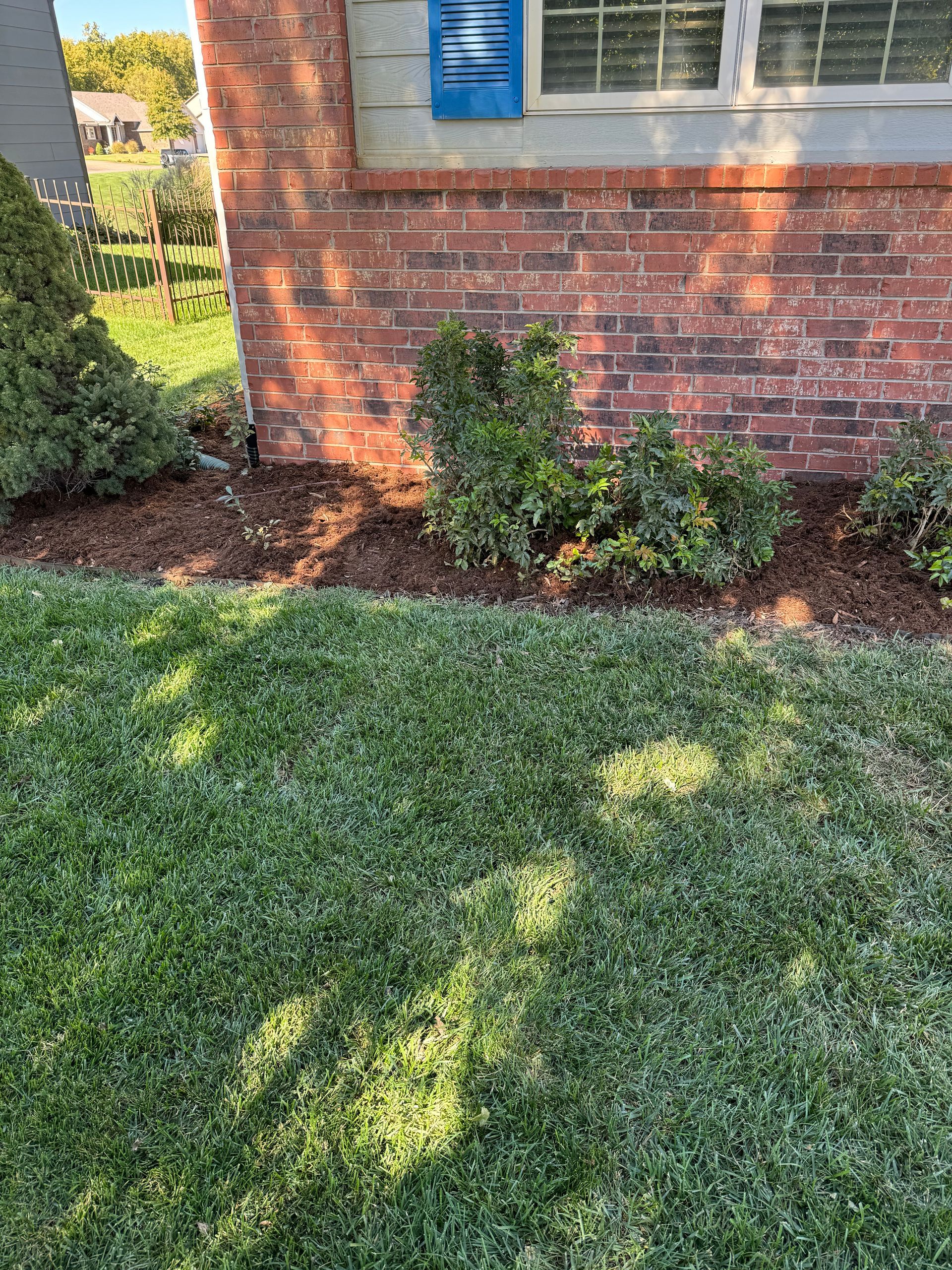 a brick house with a lush green lawn in front of it .