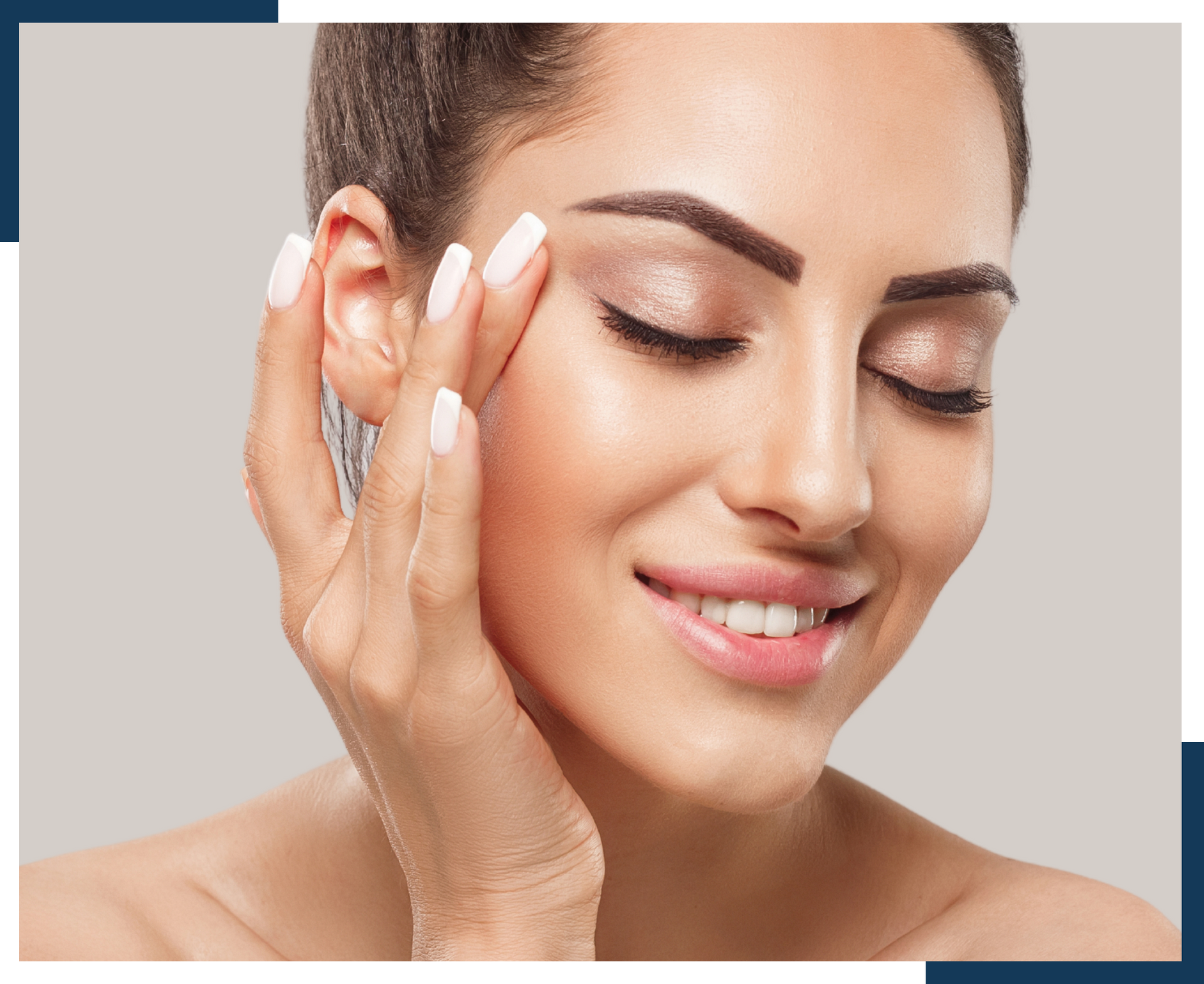 A woman is touching her face with her hand and smiling.
