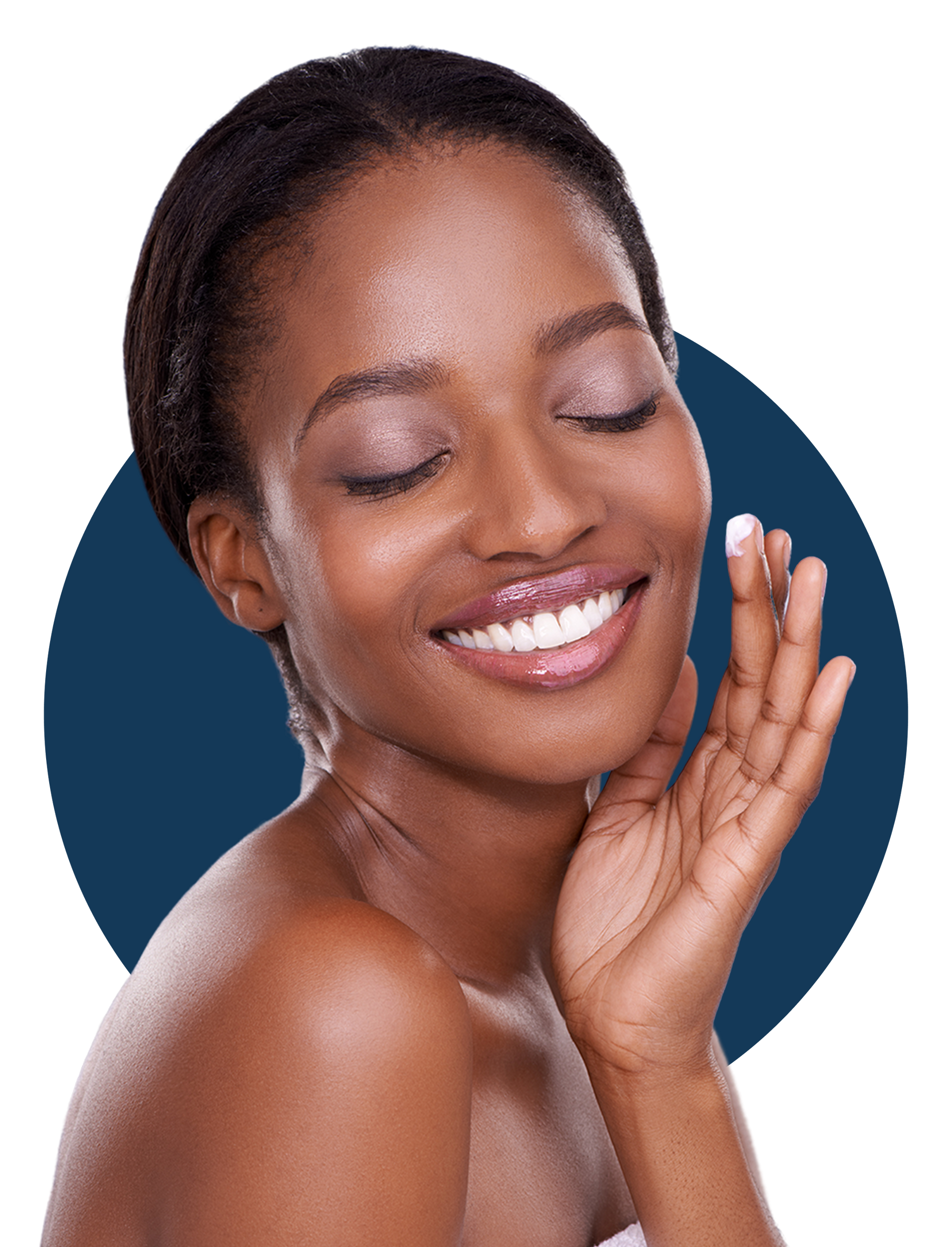 A woman is smiling and touching her face with her hand.