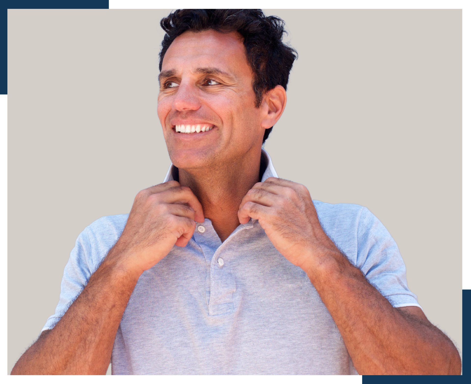 A man is smiling while adjusting his polo shirt.