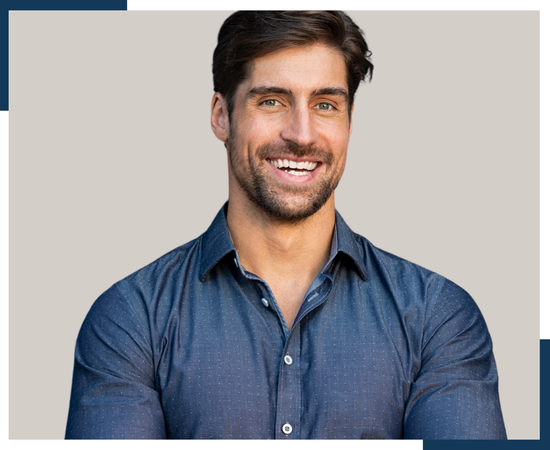 A man in a blue shirt is smiling and looking at the camera.