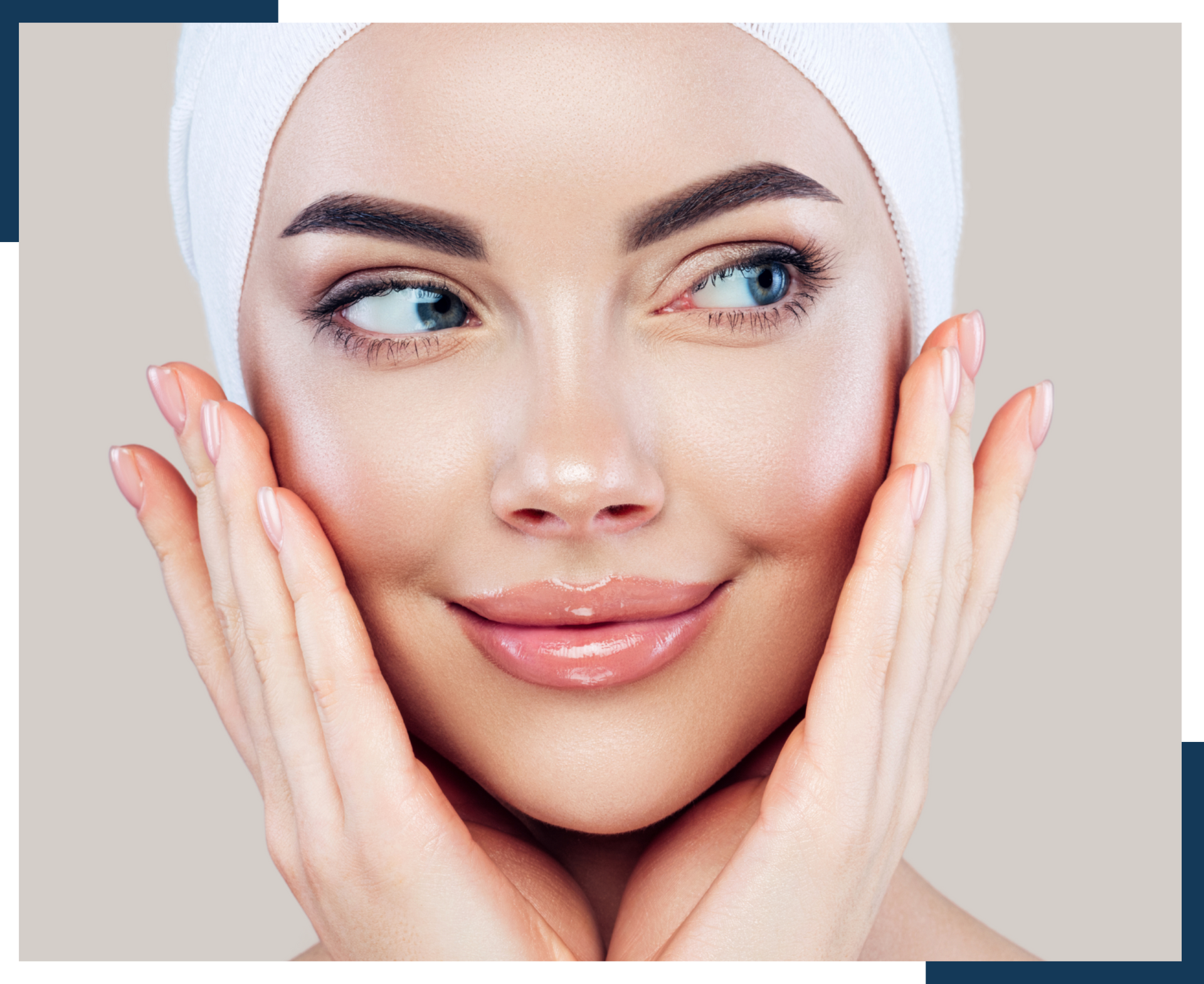A woman is touching her face with her hands and smiling.