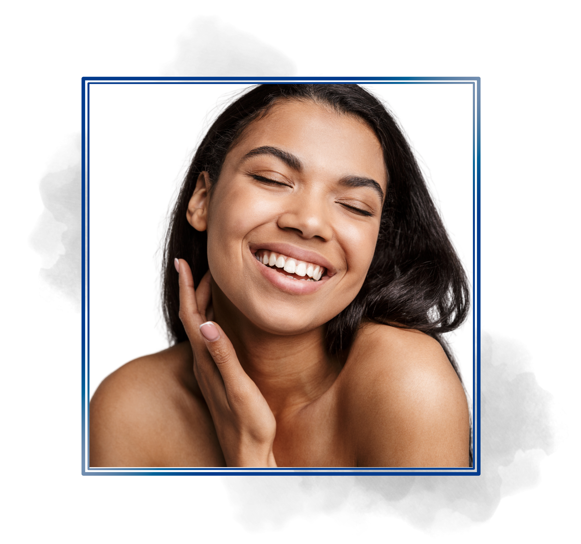 A woman is smiling with her eyes closed and touching her face.