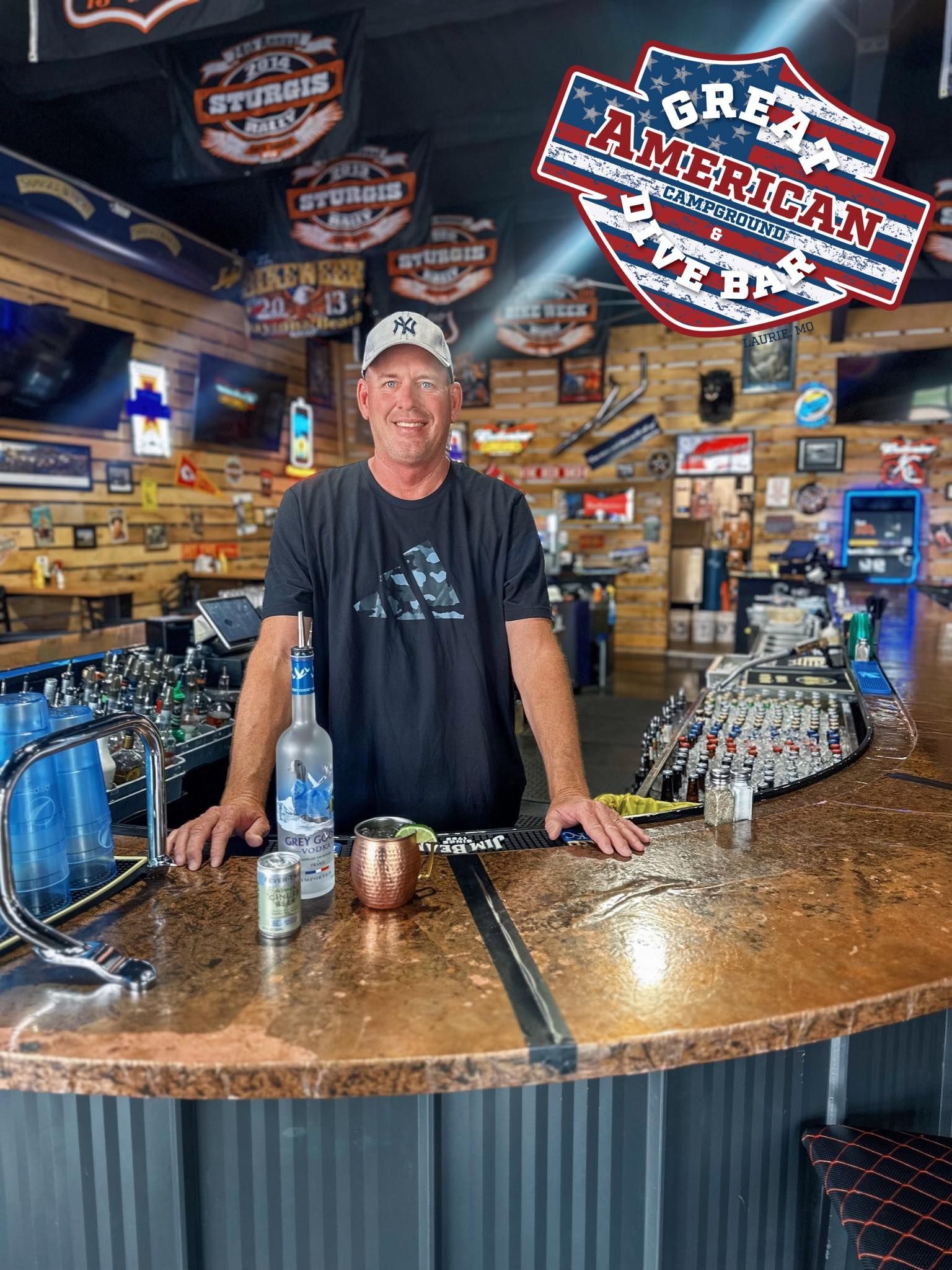 A group of people are sitting at tables in a restaurant with a tv in the background