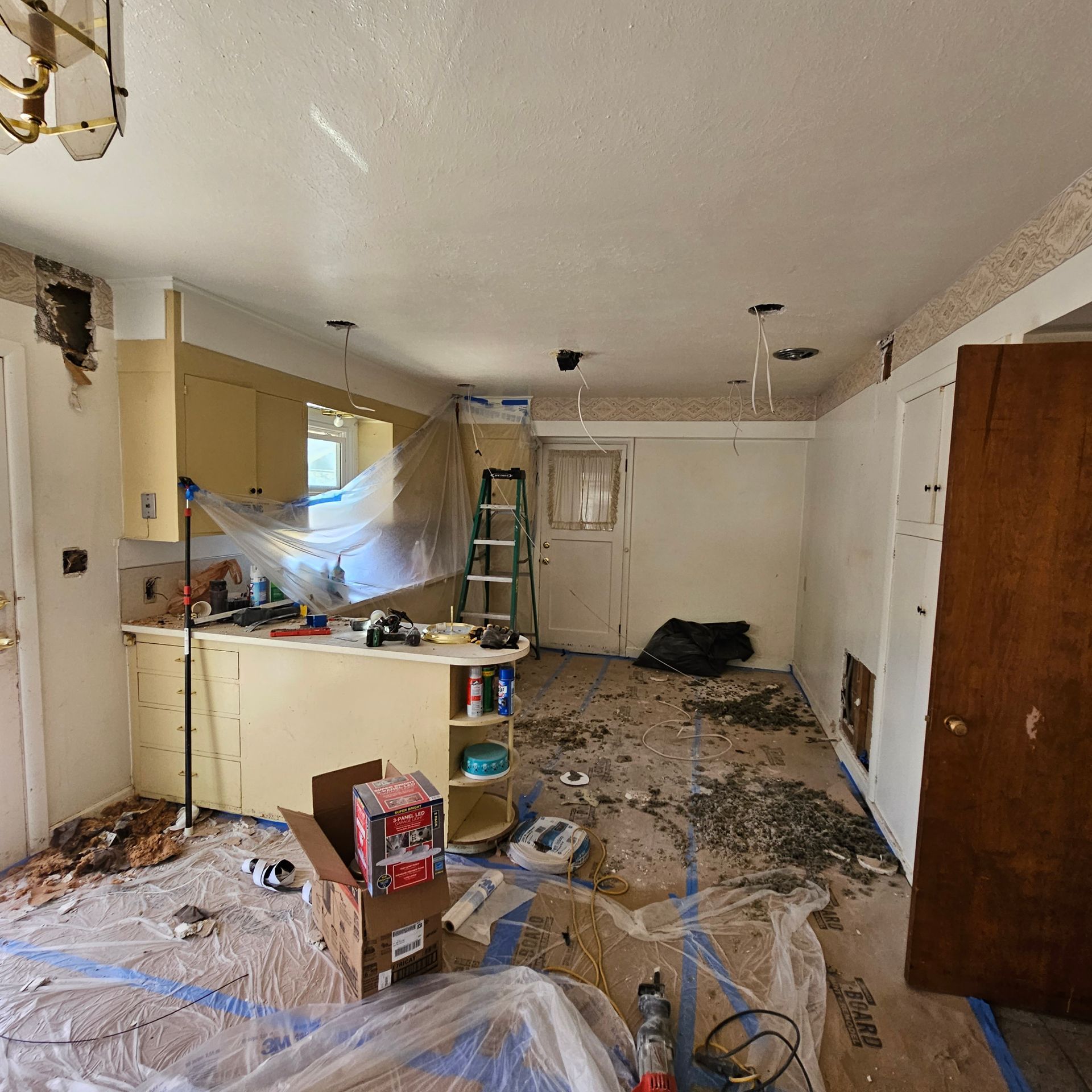A kitchen with gray cabinets and a stove top oven.