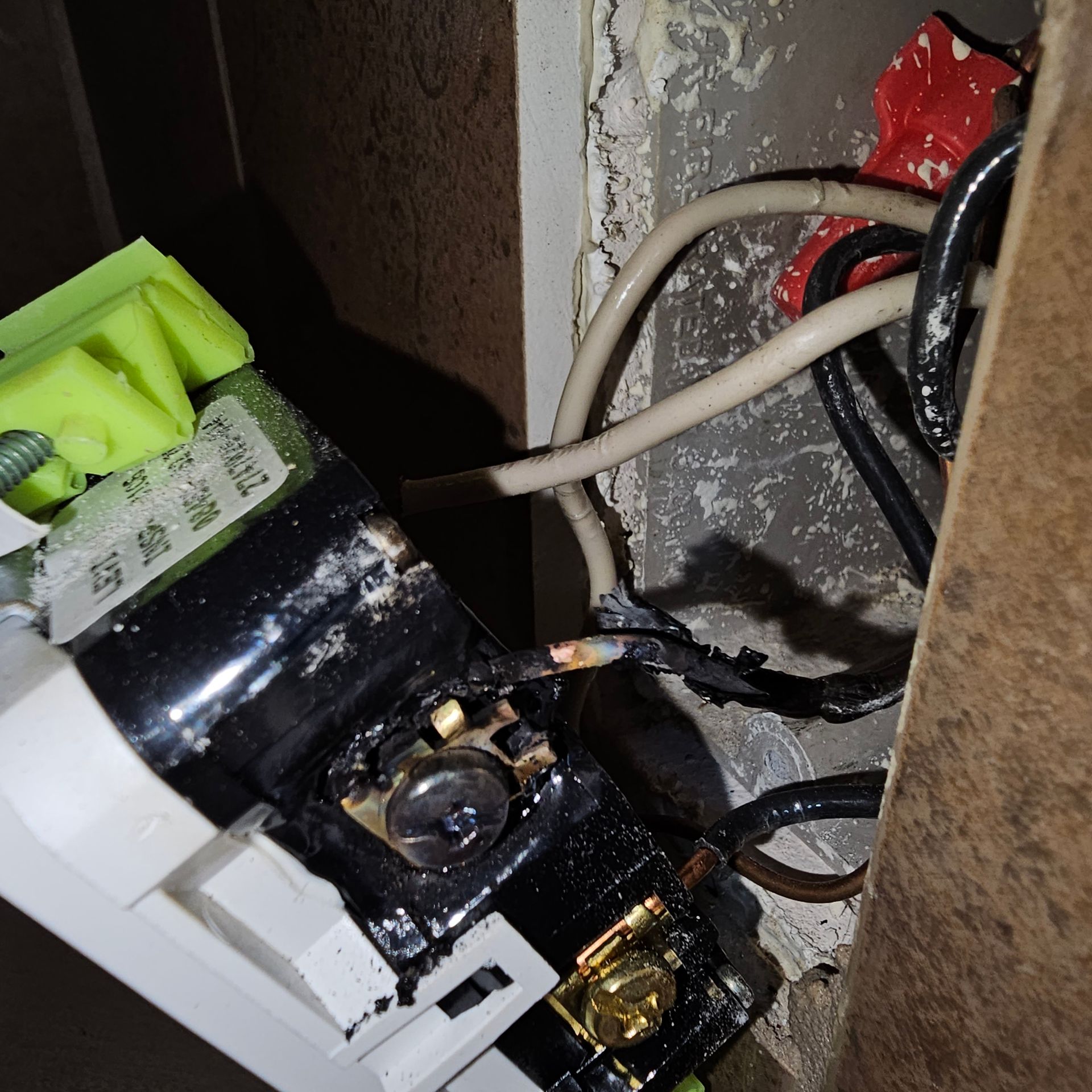 There is a meter on the side of a building next to a window.