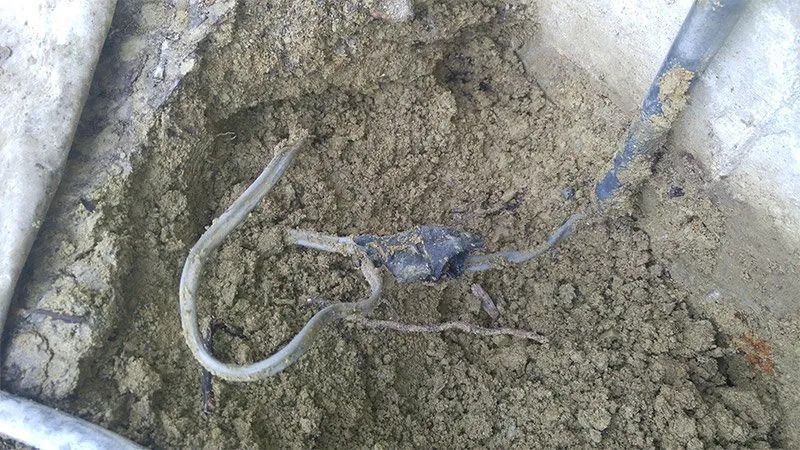A close up of a hook in a pile of dirt.