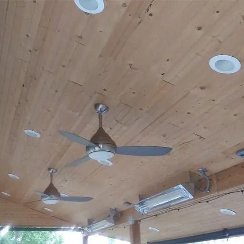 A ceiling fan is hanging from the ceiling of a wooden room.