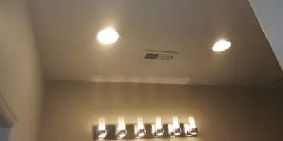 A bathroom with a vanity light hanging from the ceiling.