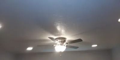 A ceiling fan is hanging from the ceiling of a room.